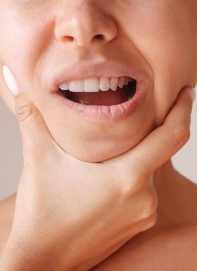 cropped-shot-young-woman-suffering-from-jaw-pain-holding-her-chin-diseases-ent-organs